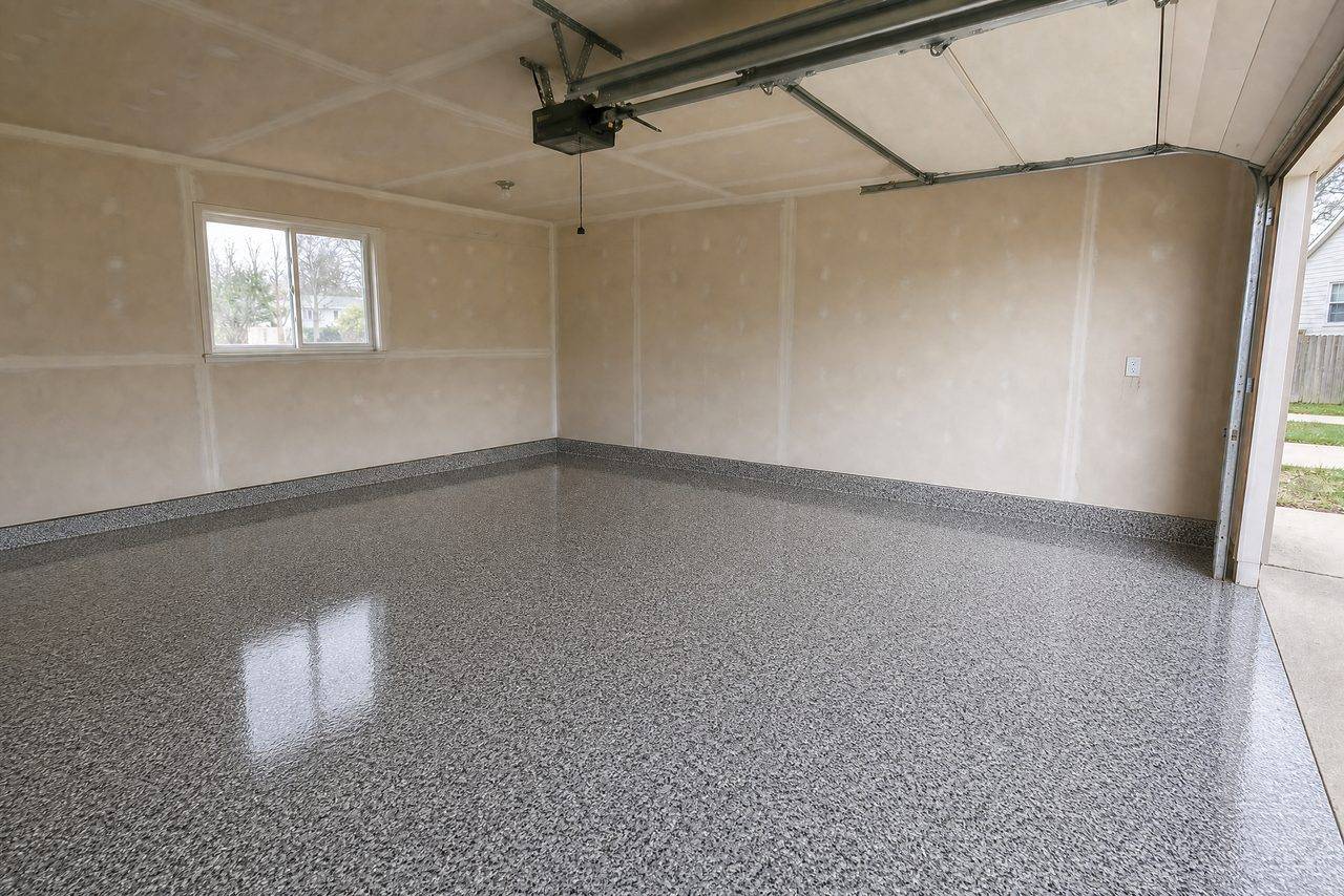 The same two-car garage after a gray and white flake epoxy floor was installed
