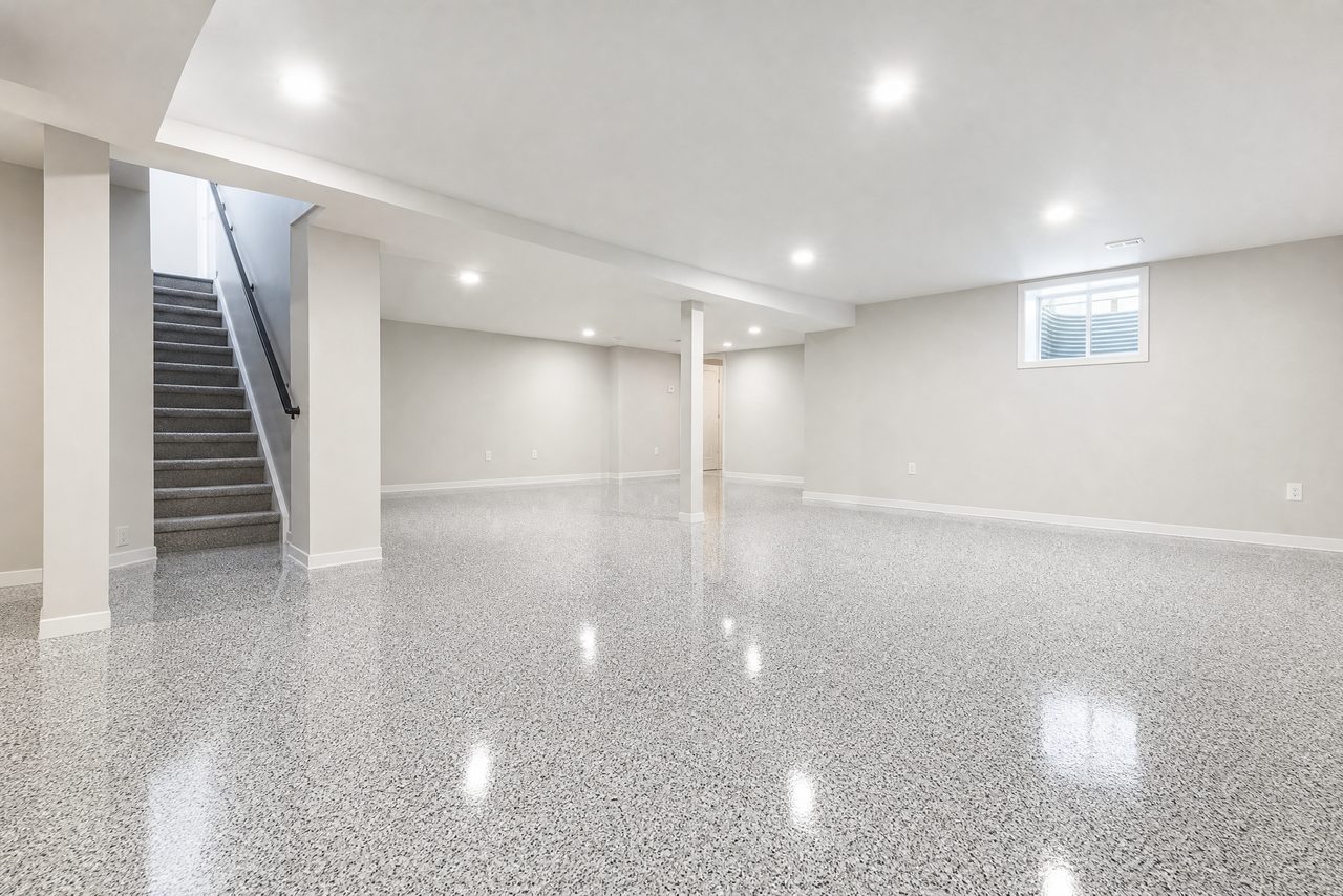 Finished residential basement with a light gray and white flake epoxy floor