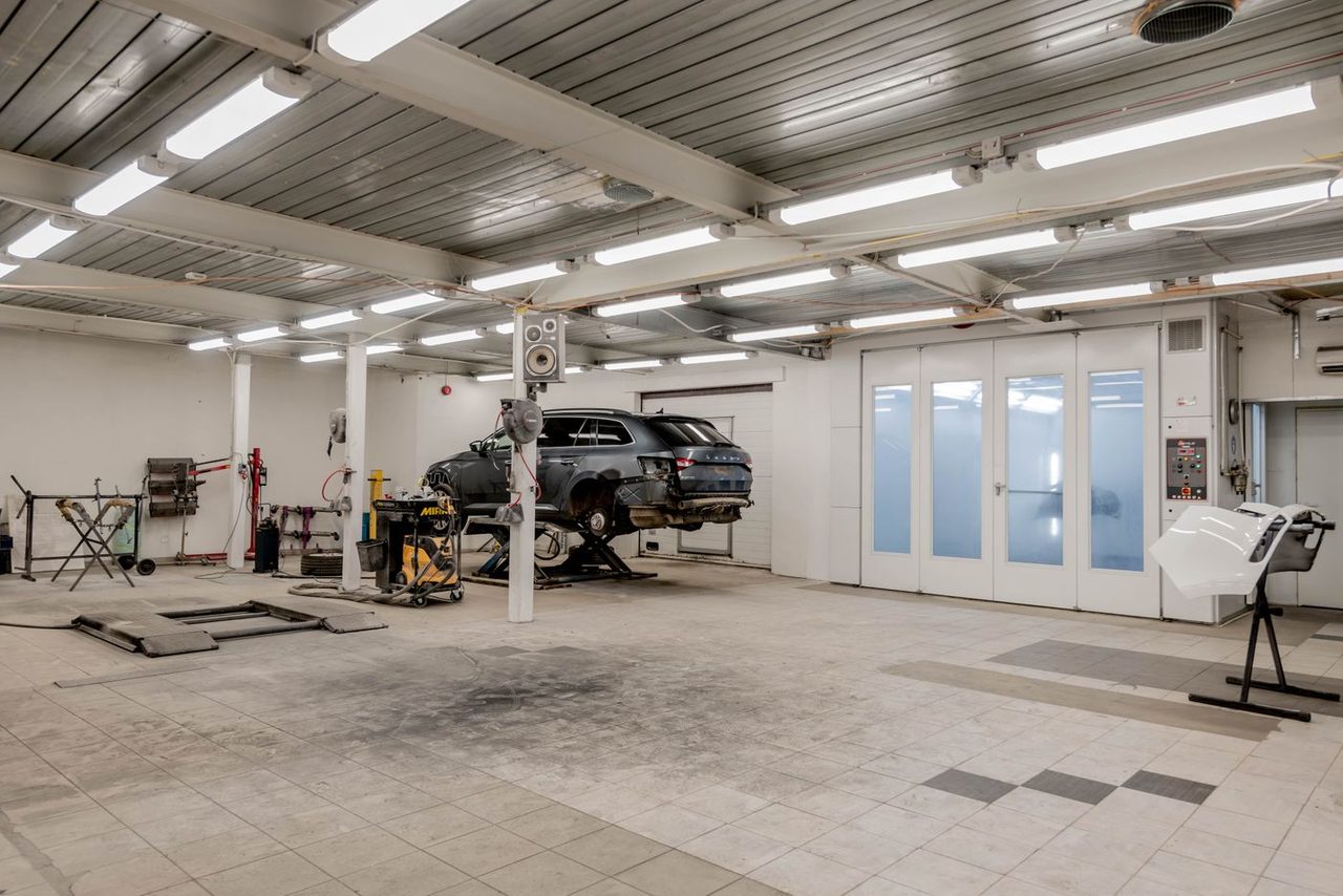 Service shop with dusty untreated concrete floor before coating