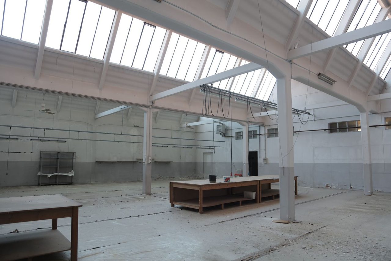 Empty warehouse before coating, showing bare gray concrete