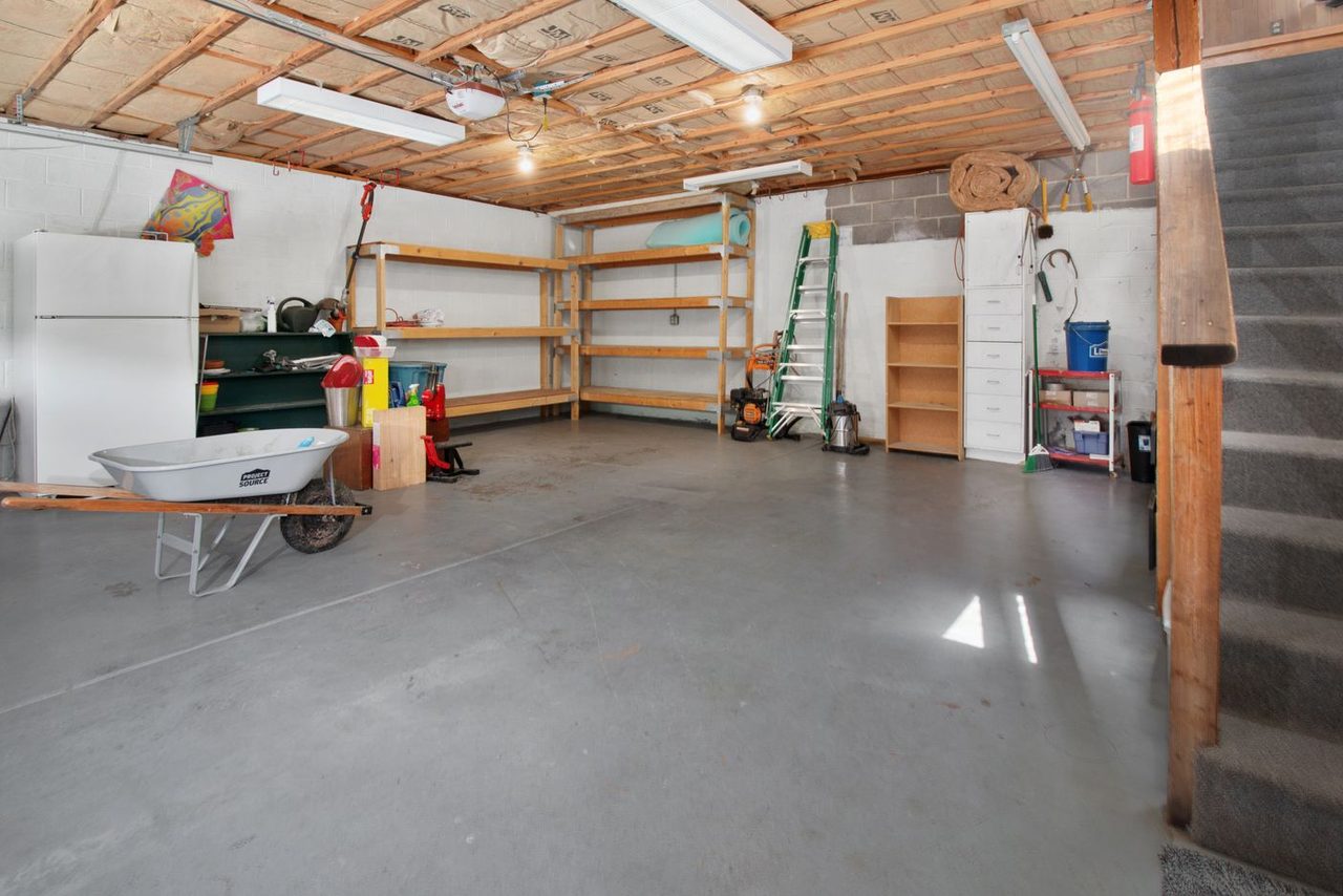 Garage workshop with a clean coated gray floor and storage shelving