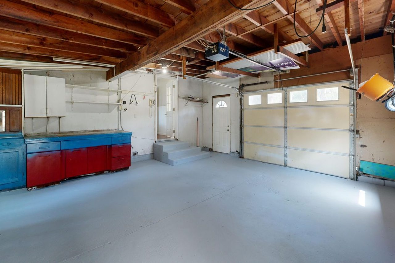 Empty residential garage with storage cabinets and a smooth gray floor