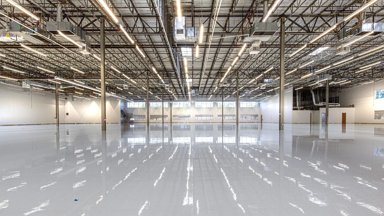 Large commercial interior with a freshly installed high-gloss epoxy floor reflecting the overhead lights