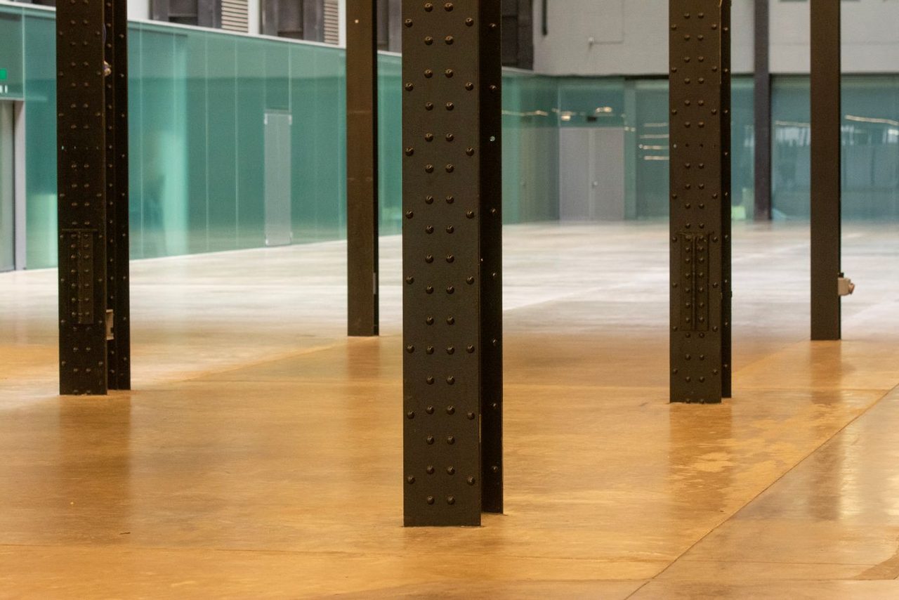 Large interior with a poured metallic epoxy floor in an amber blend and steel columns