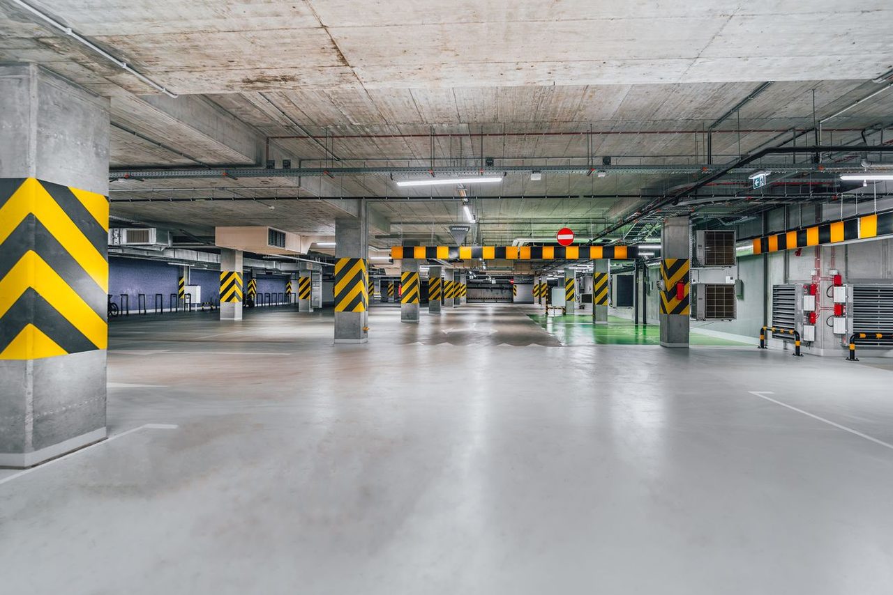 Smooth, light gray floor in a large parking structure, like the storage and shop buildings we coat around Clinton, IL
