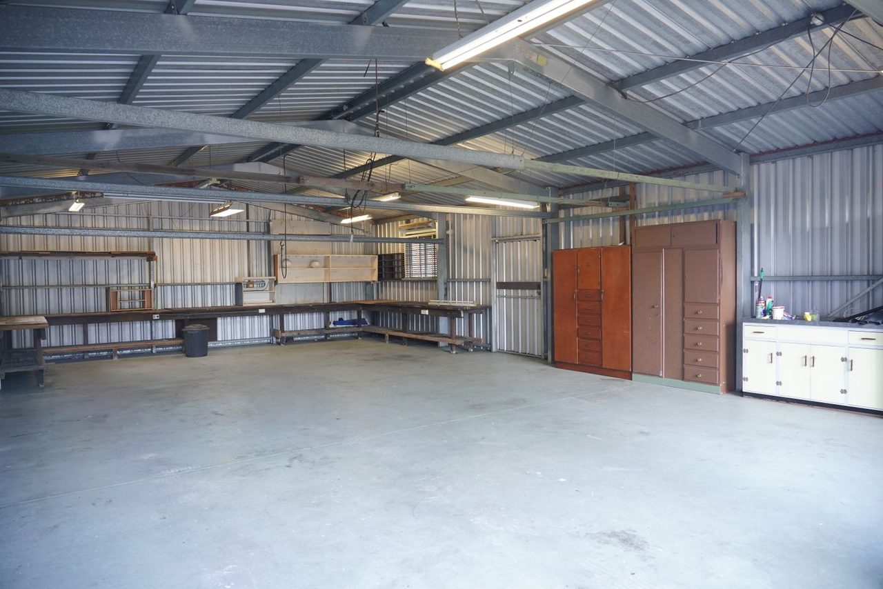 Steel-sided farm shop with a bare concrete floor &mdash; the kind of slab we prepare and coat around Paxton, IL